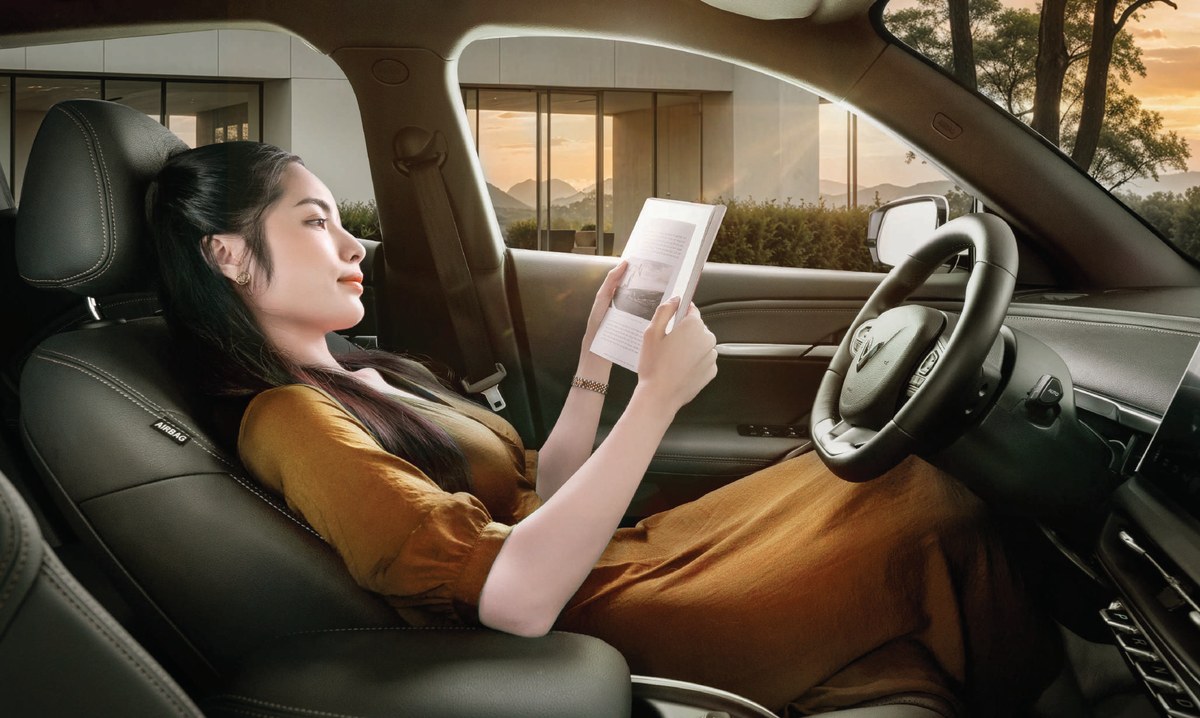 Ghế ngồi bọc da nhân tạo bên trong VinFast VF6, hành khách đang đọc sách